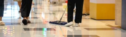 Cleaning lady sweeping the corridor in the shopping mall Cleaning lady sweeping the corridor in the shopping mall